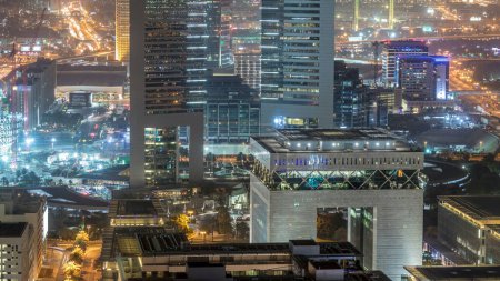 Foto de Vista panorámica de los edificios de Sheikh Zayed Road y el timelapse nocturno DIFC en Dubai, Emiratos Árabes Unidos. Rascacielos iluminados en el centro financiero vista aérea desde arriba - Imagen libre de derechos