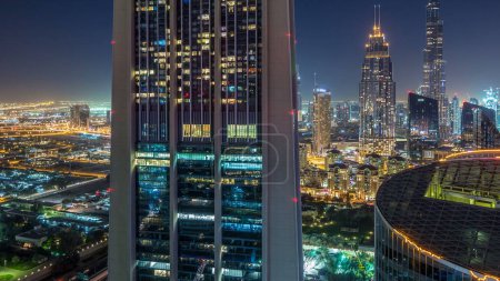 Foto de Dubai horizonte céntrico noche timelapse con el edificio más alto y Sheikh Zayed tráfico por carretera, Emiratos Árabes Unidos. Vista aérea desde la azotea de rascacielos con torres modernas iluminadas - Imagen libre de derechos