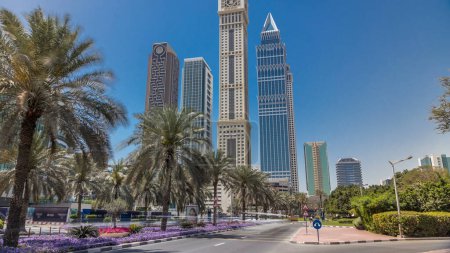 Téléchargez les photos : Les gratte-ciel modernes de la skyline le long du centre d'affaires de Sheikh Zayed Road timelapse à Dubaï, Émirats arabes unis. Palmiers dans la rue et la circulation - en image libre de droit