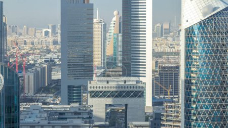 Foto de Vista panorámica de los edificios de Sheikh Zayed Road y DIFC timelapse en Dubai, Emiratos Árabes Unidos. Rascacielos y arco en vista aérea del centro financiero desde arriba antes del atardecer - Imagen libre de derechos