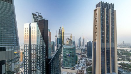 Téléchargez les photos : Vue panoramique des immeubles de bureaux sur Sheikh Zayed Road et DIFC de jour comme de nuit à Dubaï, Émirats arabes unis. gratte-ciel dans le centre financier vue aérienne d'en haut après le coucher du soleil - en image libre de droit