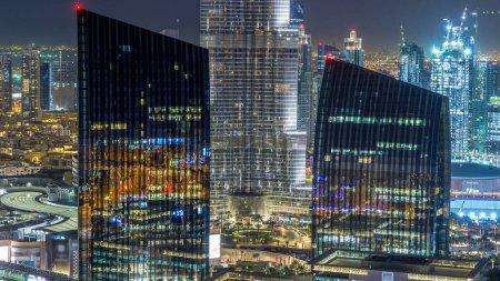 Téléchargez les photos : Dubaï ville skyline nuit timelapse avec le plus haut bâtiment et la circulation routière de l'autoroute, EAU. Vue aérienne depuis le toit des gratte-ciel de bureau avec des tours modernes éclairées - en image libre de droit