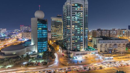 Téléchargez les photos : Dubaï Creek zone entourée de bâtiments modernes et animé rue de la circulation nuit timelapse. Vue aérienne du dessus avec des gratte-ciel éclairés - en image libre de droit