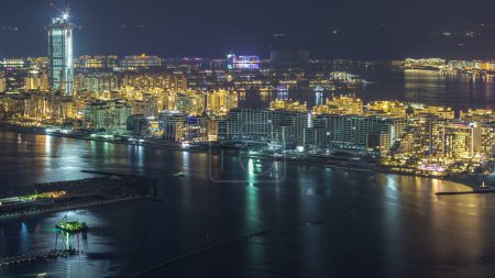Foto de Vista aérea del timelapse nocturno de Palm Jumeirah Island. Vista superior con villas iluminadas, hoteles y yates. Algunos edificios están en construcción - Imagen libre de derechos