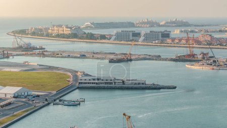 Téléchargez les photos : Vue aérienne du timelapse de Palm Jumeirah Island. Vue panoramique en soirée avec villas, hôtels et yachts. Processus de construction du nouveau terminal de croisière - en image libre de droit