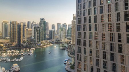 Photo for Beautiful aerial view of Dubai Marina promenade and canal with floating yachts and boats before sunset in Dubai, UAE. Modern towers and skyscrapers with windows at evening - Royalty Free Image