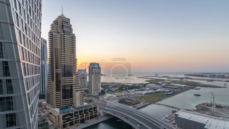 Photo for JBR and Dubai marina after sunset aerial day to night transition timelapse. Modern towers and skyscrapers, traffic on the bridge, yachts and boats floating on canal - Royalty Free Image