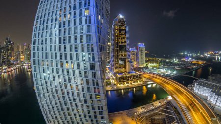 Photo for JBR and Dubai marina aerial panorama night timelapse. Illuminated modern towers and skyscrapers, traffic on the bridge, yachts and boats floating on canal - Royalty Free Image