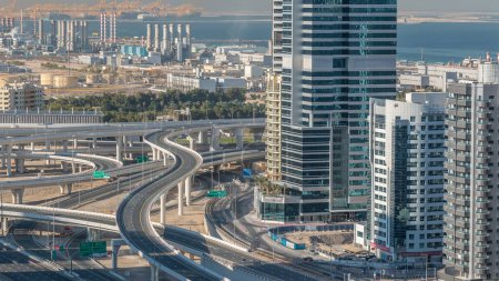 Téléchargez les photos : Vue aérienne d'une intersection de la route cheikh zayed dans une grande ville timelapse. Paysage urbain du quartier Marina de Dubaï aux EAU avec des voitures - en image libre de droit