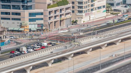 Foto de Vista aérea de una intersección de carreteras en un gran lapso de tiempo de la ciudad. Paisaje urbano del distrito de Dubai Marina en los Emiratos Árabes Unidos con coches y tranvía - Imagen libre de derechos