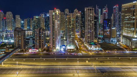 Photo for Fantastic rooftop skyline of Dubai marina timelapse. Illuminated skyscrapers of a big city by night, United Arab Emirates. Aerial view from JLT - Royalty Free Image