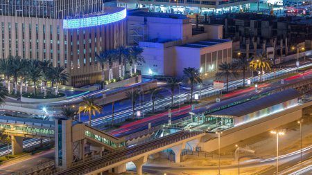 Foto de Vista aérea del tranvía de Dubái en Dubai puerto deportivo timelapse noche. Dubai Tranvía se ejecuta en un bucle alrededor de Marina y JBR área y se conecta con el Metro de Dubai y el Palm Monorail
. - Imagen libre de derechos