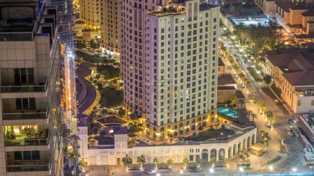 Téléchargez les photos : Vue aérienne des gratte-ciel et de la plage éclairés modernes de la résidence Jumeirah Beach Residence (JBR), à Dubaï, Émirats arabes unis. Bateaux et yachts flottant sur l'eau du Golfe - en image libre de droit