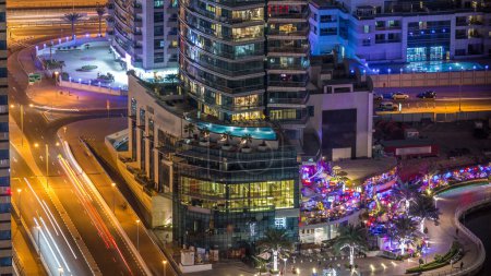 Téléchargez les photos : Canal de luxe de Dubai Marina et promenade avec restaurants nuit timelapse, la circulation sur le pont. Vue de dessus avec des gratte-ciel éclairés. Dubai, Émirats arabes unis - en image libre de droit