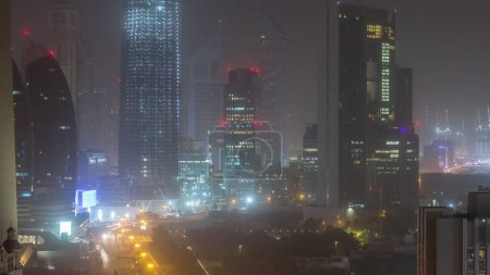 Téléchargez les photos : Dubaï skyline night to day aerial timelapse with traffic on highway, UAE. Vue de dessus depuis le toit du gratte-ciel avec des tours modernes avec la rue Al Saada - en image libre de droit