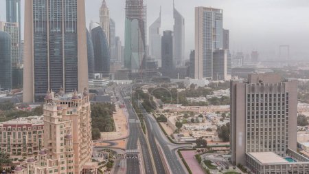 Foto de Dubai skyline centro en la mañana nublado timelapse con el tráfico en la carretera, Emiratos Árabes Unidos. Vista superior desde la azotea del rascacielos con torres modernas cerca de la calle Al Saada - Imagen libre de derechos