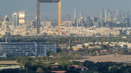 Foto de Vista panorámica del distrito de Deira con rayos de luz solar reflejados desde rascacielos en Dubai timelapse antes del atardecer, Emiratos Árabes Unidos. Vista aérea desde la azotea en el centro de Dubai
. - Imagen libre de derechos