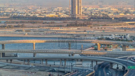 Photo for Construction with cranes and intersection near Dubai Creek Harbor aerial timelapse. Dubai - UAE. Top view from Dubai downtown with traffic on a highway - Royalty Free Image