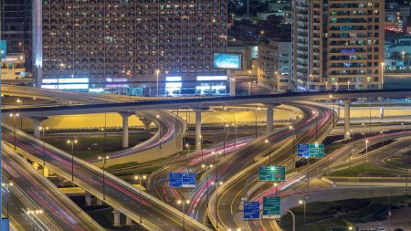 Téléchargez les photos : Vue aérienne de l'échangeur de l'autoroute dans le centre-ville de Dubaï timelapse de nuit. Paysages urbains pont de circulation, logistique. Routes et ruelles Crossroads, Dubaï, Émirats arabes unis - en image libre de droit