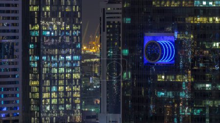 Foto de Rascacielos vista aérea de cerca en el centro y el distrito financiero Dubai noche timelapse, luces parpadeantes. Emiratos Árabes Unidos con torres iluminadas
. - Imagen libre de derechos