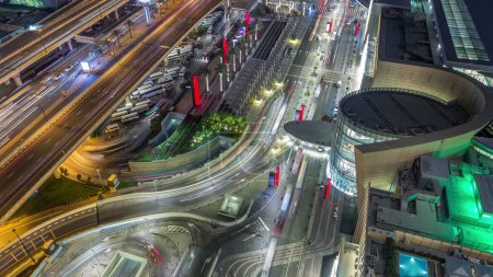 Téléchargez les photos : Vue aérienne de l'entrée du centre commercial avec centre financier route nuit circulation timelapse et arrêt de bus du centre-ville de Dubaï - en image libre de droit