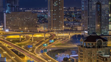 Foto de Vista aérea del intercambio de carreteras en el centro de Dubái noche a día timelapse transición. Paisajes urbanos puente de tráfico, logística. Carreteras y carriles Crossroads, Dubai, Emiratos Árabes Unidos - Imagen libre de derechos