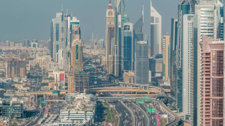 Téléchargez les photos : Des gratte-ciel sur Sheikh Zayed Road et DIFC Aerial Timelapse à Dubaï, Émirats Arabes Unis. Circulation sur une autoroute près du Centre financier le soir avant le coucher du soleil - en image libre de droit