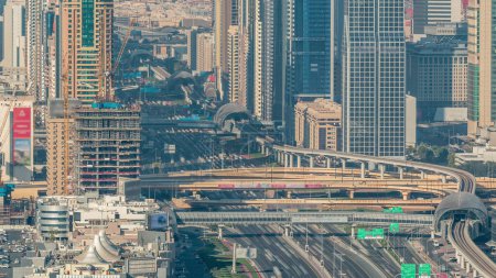 Téléchargez les photos : Des gratte-ciel sur Sheikh Zayed Road et DIFC Aerial Timelapse à Dubaï, Émirats Arabes Unis. Circulation sur une autoroute et intersection près du Centre financier le soir avant le coucher du soleil - en image libre de droit