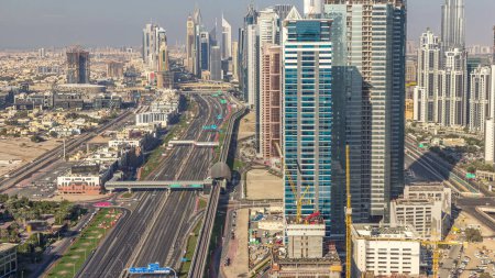 Téléchargez les photos : Des gratte-ciel sur Sheikh Zayed Road et DIFC Aerial Timelapse à Dubaï, Émirats Arabes Unis. Circulation sur une autoroute près du Centre financier le soir avant le coucher du soleil - en image libre de droit