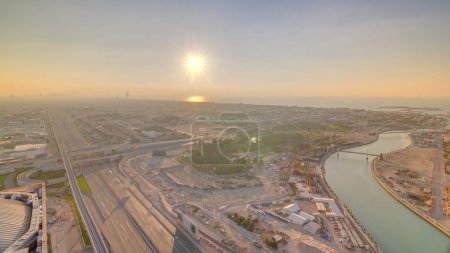 Foto de Panorama y vista aérea de la costa de Dubai al atardecer, Emiratos Árabes Unidos. Canal de agua de Dubai, camino sheikh zayed, casas y villas desde arriba - Imagen libre de derechos