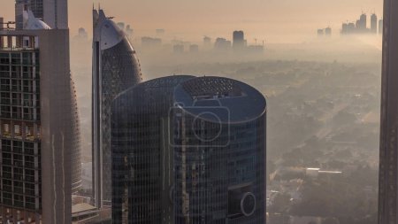 Foto de Dubai centro durante el amanecer dorado escena de la mañana timelapse. Vista aérea desde arriba con niebla y edificios del puerto del arroyo Dubai en el fondo - Imagen libre de derechos