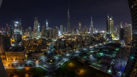 Foto de Dubai Centro skyline transición día a día con Burj Khalifa y otras torres vista panorámica desde la parte superior en Dubai, Emiratos Árabes Unidos. Tráfico en la carretera circular. Edificios tradicionales y modernos. - Imagen libre de derechos