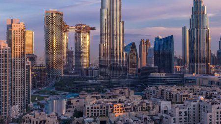 Dubai Centro skyline durante el amanecer timelapse con Burj Khalifa y otras torres vista panorámica desde la parte superior en Dubai, Emiratos Árabes Unidos. Sol reflejado en la superficie de cristal del rascacielos