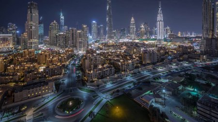 Aerial view of a roundabout circle road in Dubai downtown with old style traditional buildings from above night timelapse. Traffic on the street. Dubai, United Arab Emirates.