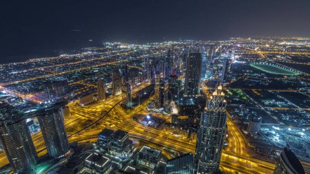 Téléchargez les photos : Centre-ville et et quartier financier de Dubaï nuit timelapse. Ciel nuageux et circulation sur l'autoroute. Vue aérienne avec tours et gratte-ciel du point de vue de Burj Khalifa
. - en image libre de droit
