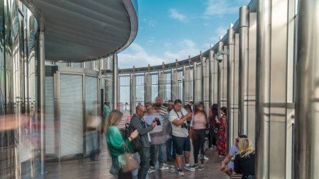 Photo for Tourists meet sunrise at the observation deck on the 125 floor of Burj Khalifa tower timelapse. Crowd making photos from the top - Royalty Free Image
