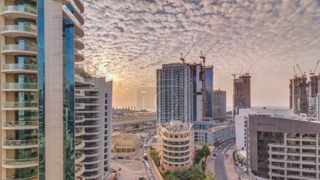 Téléchargez les photos : Dubai Marina au coucher du soleil avec gratte-ciel et promenade aérienne timelapse. Tours et bateaux modernes d'en haut, port avec des yachts de luxe. Émirats arabes unis - en image libre de droit