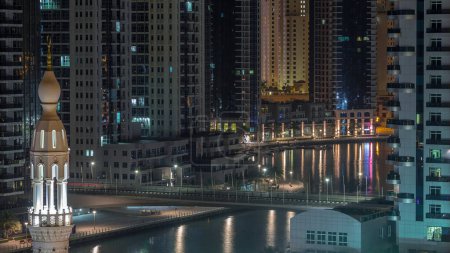 Téléchargez les photos : Dubai Marina avec des gratte-ciel éclairés et promenade aérienne nuit à jour passage timelapse. Tours et bateaux modernes d'en haut avec circulation sur un pont. Émirats arabes unis - en image libre de droit
