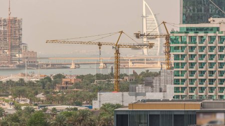 Téléchargez les photos : Vue aérienne de l'horizon de la plage à JBR timelapse à Dubaï, Émirats Arabes Unis. Gratte-ciels et palmiers jumeirah sur un fond. Bord de l'eau avec de nombreuses activités et attractions - en image libre de droit