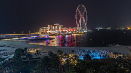 Photo for Bluewaters island and JBR aerial night timelapse with ferris wheel, new walking area with shopping mall and restaurants, newly opened leisure and travel spot in Dubai - Royalty Free Image