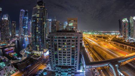 Foto de Vista panorámica aérea a los rascacielos de Dubai Marina y al timelapse nocturno Sheikh Zayed, Dubai. Tráfico, puentes y línea de metro. Emiratos Árabes Unidos - Imagen libre de derechos