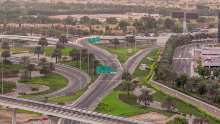 Luftaufnahme von der Kreuzung an der Sheikh Zayed Road in der Nähe des Jachthafens von Dubai und jlt Wolkenkratzer im morgendlichen Zeitraffer, Dubai. Verkehr, Brücken und U-Bahn-Linie. Vereinigte Arabische Emirate