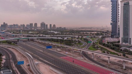 Téléchargez les photos : Vue aérienne vers Sheikh Zayed road près de Dubai Marina et JLT skyscrapers morning timelapse, Dubai. Trafic, ponts et ligne de métro. Ciel nuageux après le coucher du soleil. Émirats arabes unis - en image libre de droit