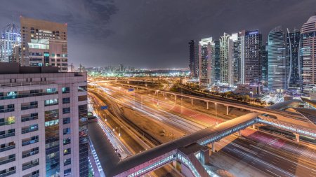 Téléchargez les photos : Vue aérienne vers Sheikh Zayed route entourée Dubai Marina et JLT gratte-ciel nuit timelapse, Dubaï. Trafic, ponts et ligne de métro. Émirats arabes unis - en image libre de droit