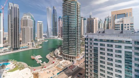 Téléchargez les photos : Vue panoramique aérienne des gratte-ciel résidentiels et de bureau de Dubai Marina avec timelapse en bord de mer. Bateaux et yachts flottants - en image libre de droit