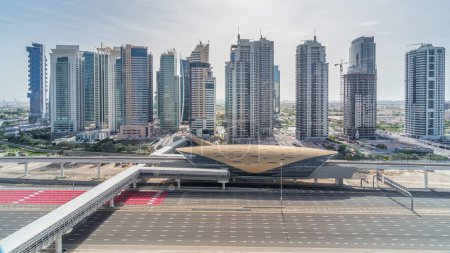 Vista aérea de la parte superior de la carretera Sheikh Zayed desde Dubai Marina con rascacielos JLT timelapse durante todo el día con sombras que se mueven rápido, Dubai. Tráfico, puentes y estación de metro. Emiratos Árabes Unidos
