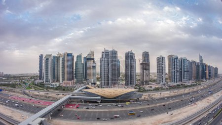 Téléchargez les photos : Vue panoramique aérienne sur la route Sheikh Zayed depuis Dubai Marina avec des gratte-ciel éclairés JLT, de jour comme de nuit, transition timelapse, Dubai. Trafic, ponts et station de métro. Émirats arabes unis - en image libre de droit