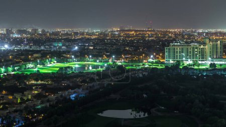 Foto de Vista aérea a villas y casas con campo de golf nocturno timelapse. Tráfico en las calles. Lagos con fuentes - Imagen libre de derechos