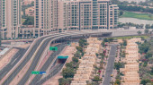 Aerial view of apartment houses and villas in Dubai city timelapse near jumeirah lake towers district, United Arab Emirates. Traffic on the road and overpass. Top view from skyscraper t-shirt #714800512