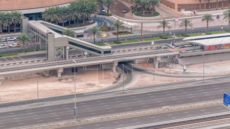 Foto de Vista aérea del tráfico cerca del centro comercial con pasarela desde el timelapse parada de tranvía en Dubai Marina en Dubai, Emiratos Árabes Unidos. Tráfico en la carretera - Imagen libre de derechos